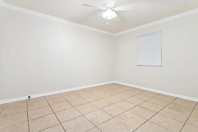 an empty room with a ceiling fan and a window