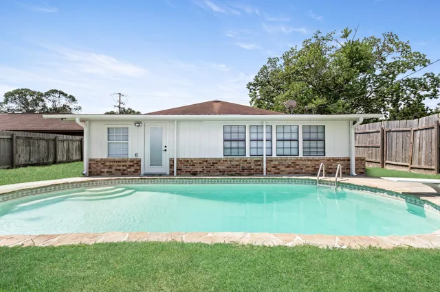a view of a house with a swimming pool and a yard