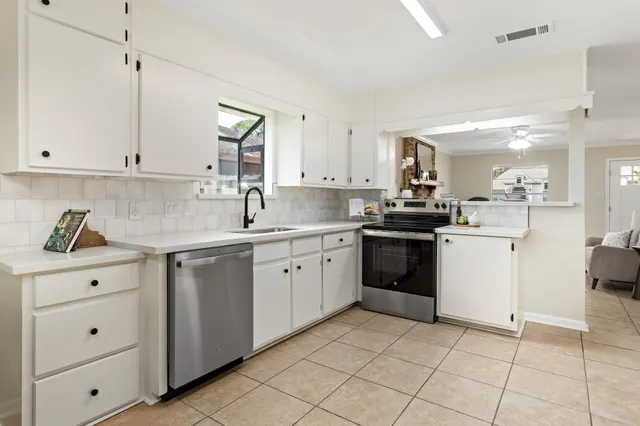 a kitchen with a stove sink and cabinets
