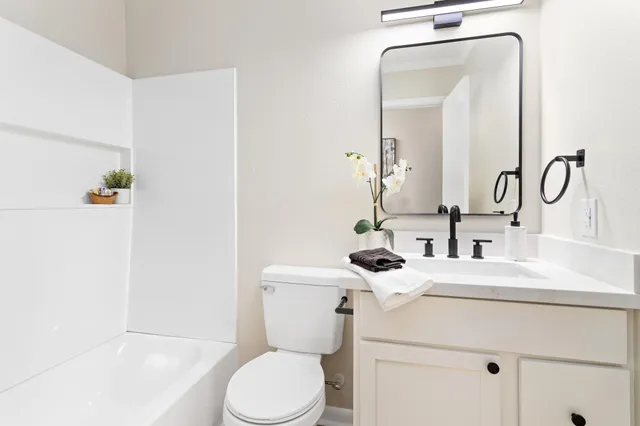 a bathroom with a sink vanity mirror and toilet