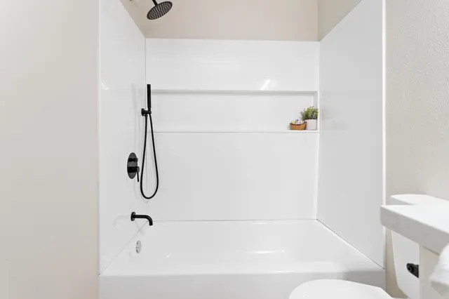 a bathroom with a bath tub with a shower