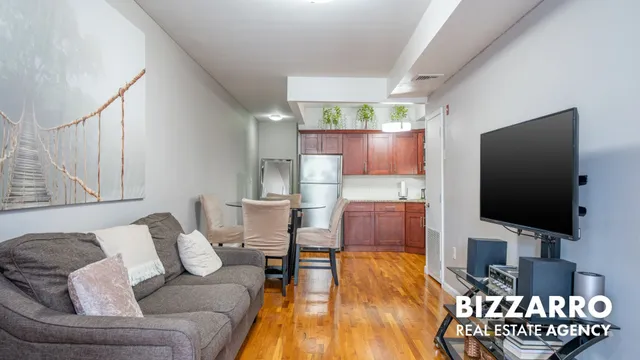 a kitchen with stainless steel appliances a dining table chairs and a refrigerator