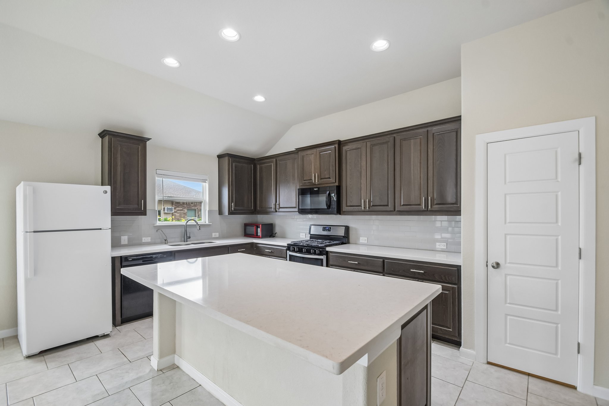 280 Rimrock Court Bastrop, TX 78602 - Photo 8 of 34 Rich dark cabinetry and a spacious central island define this modern culinary workspace.