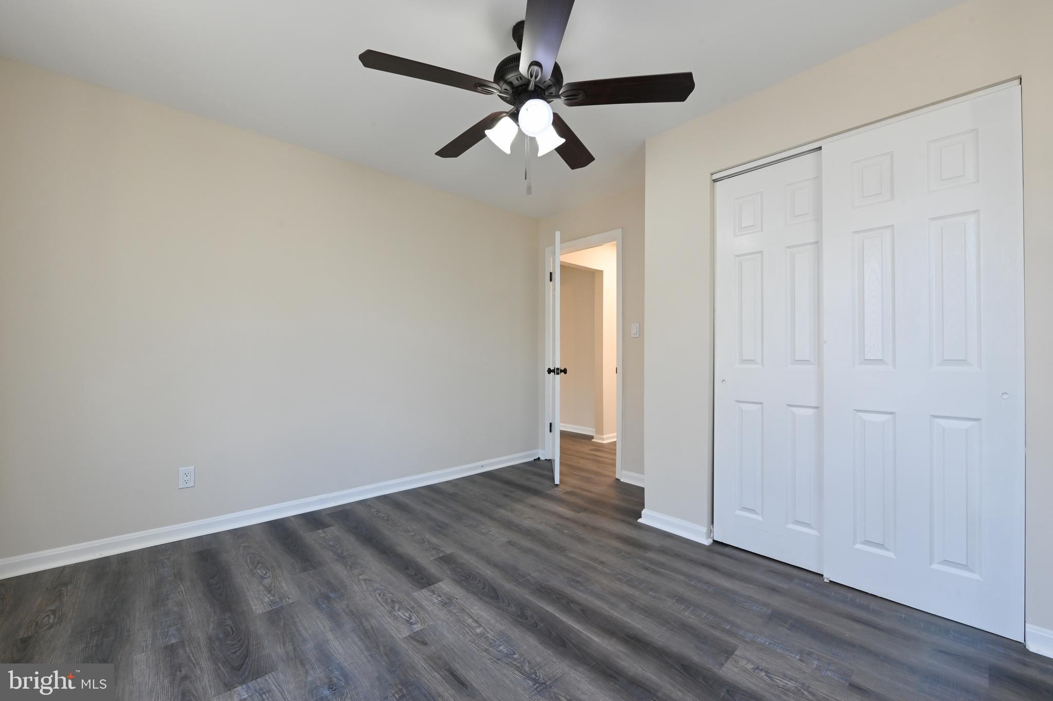 313 Orchard Road Edgewater, MD 21037 - Photo 16 of 48 an empty room with wooden floor chandelier fan and windows