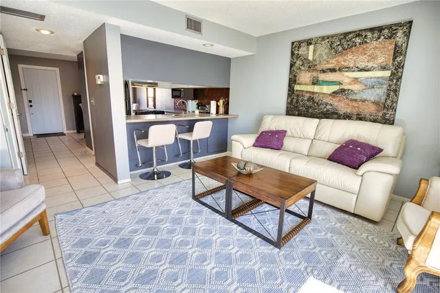 a living room with furniture and a painting on the wall