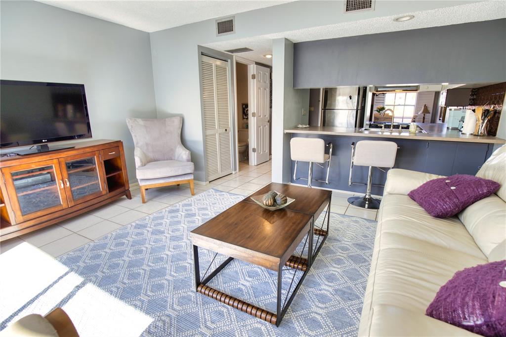 744 Cadiz Road, Unit 2 Venice, FL 34285 - Photo 14 of 26 a living room with furniture a flat screen tv and kitchen view