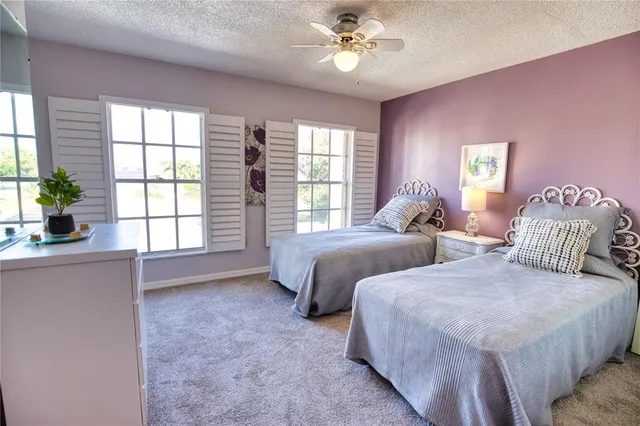 a bedroom with two beds and a large window