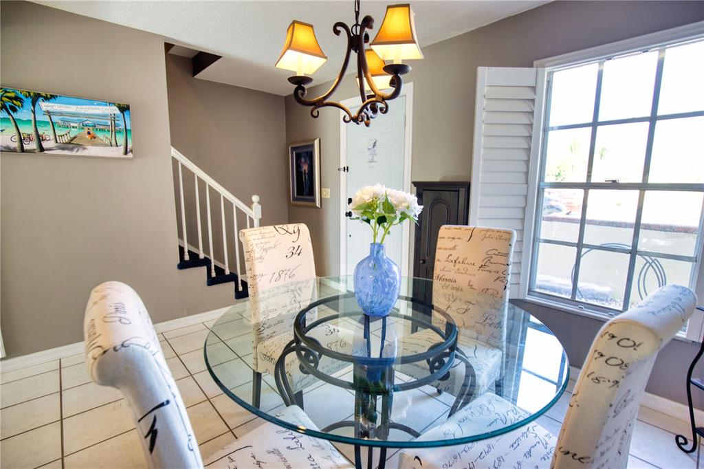 744 Cadiz Road, Unit 2 Venice, FL 34285 - Photo 4 of 26 a view of a dining room with furniture wooden floor and chandelier