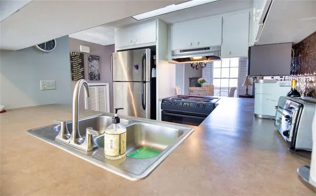 a kitchen with stainless steel appliances granite countertop a sink and a refrigerator