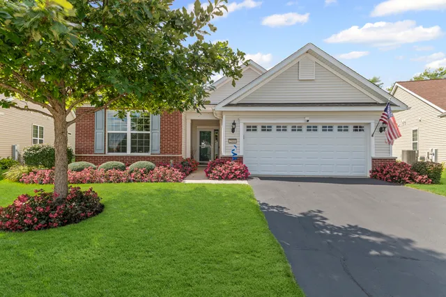 a front view of a house with a garden and plants