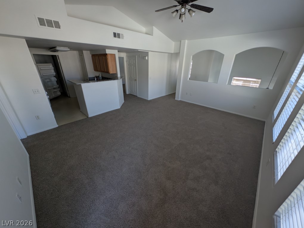 10550 West Alexander Road, Unit 2117 Las Vegas, NV 89129 - Photo 8 of 24 Vaulted ceilings and arched wall cutouts create a spacious feel in this carpeted living area.