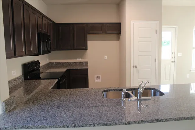 a kitchen view with microwave a sink and cabinets