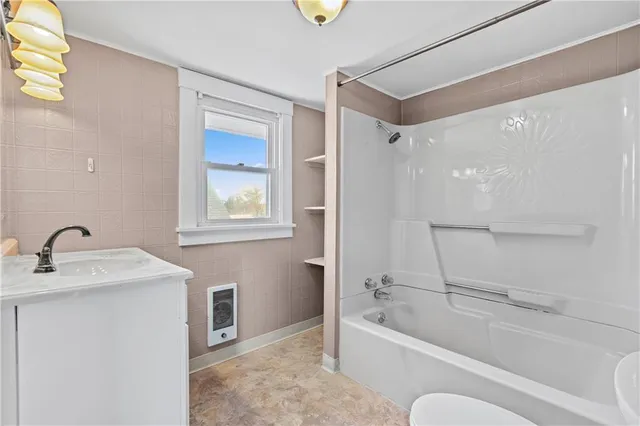 a bathroom with a tub sink and mirror