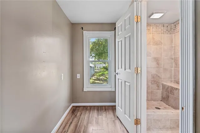 a view of a hallway with wooden floor and a window