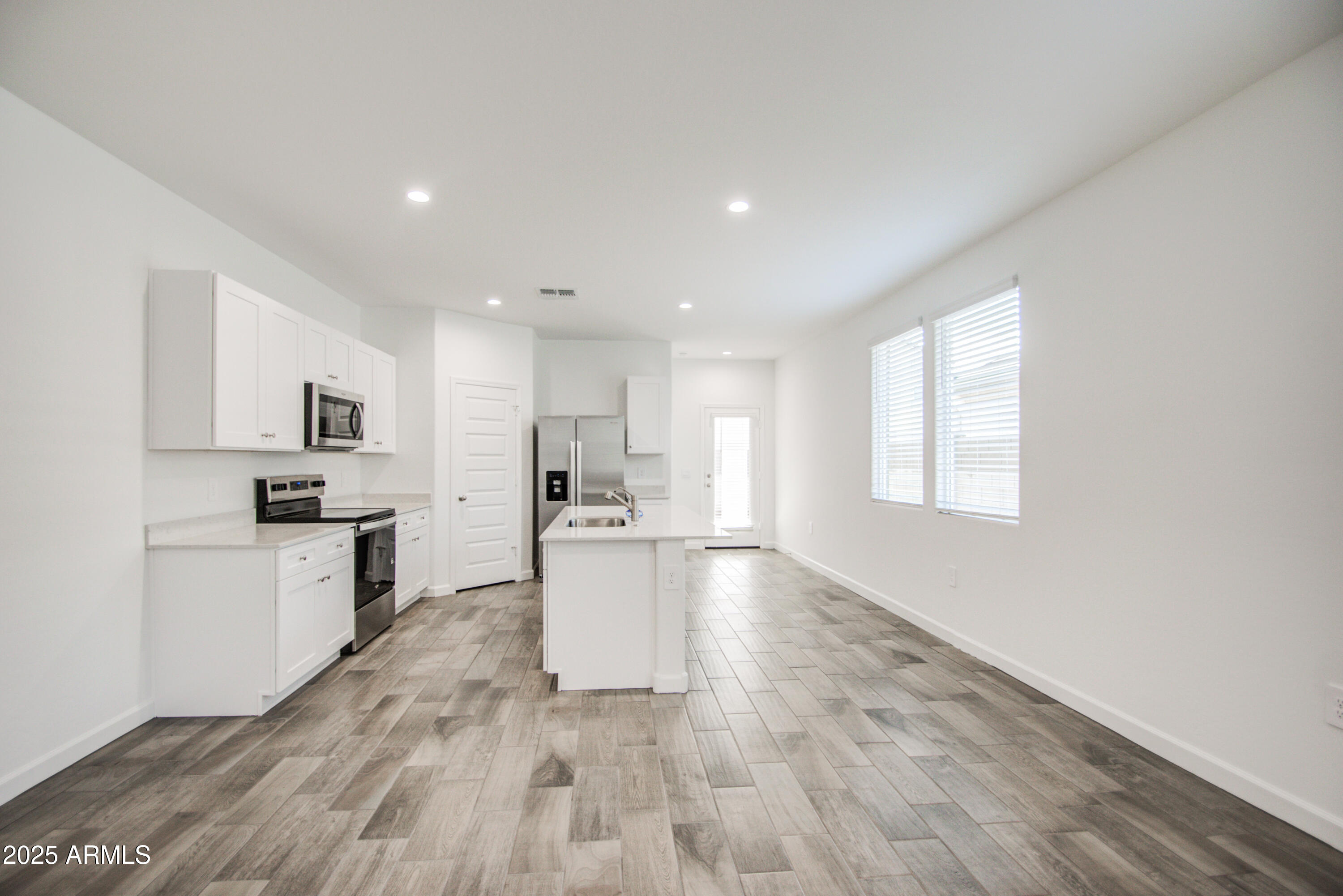 1749 West Stealth Avenue Apache Junction, AZ 85120 - Photo 11 of 48 a kitchen with white cabinets and stainless steel appliances