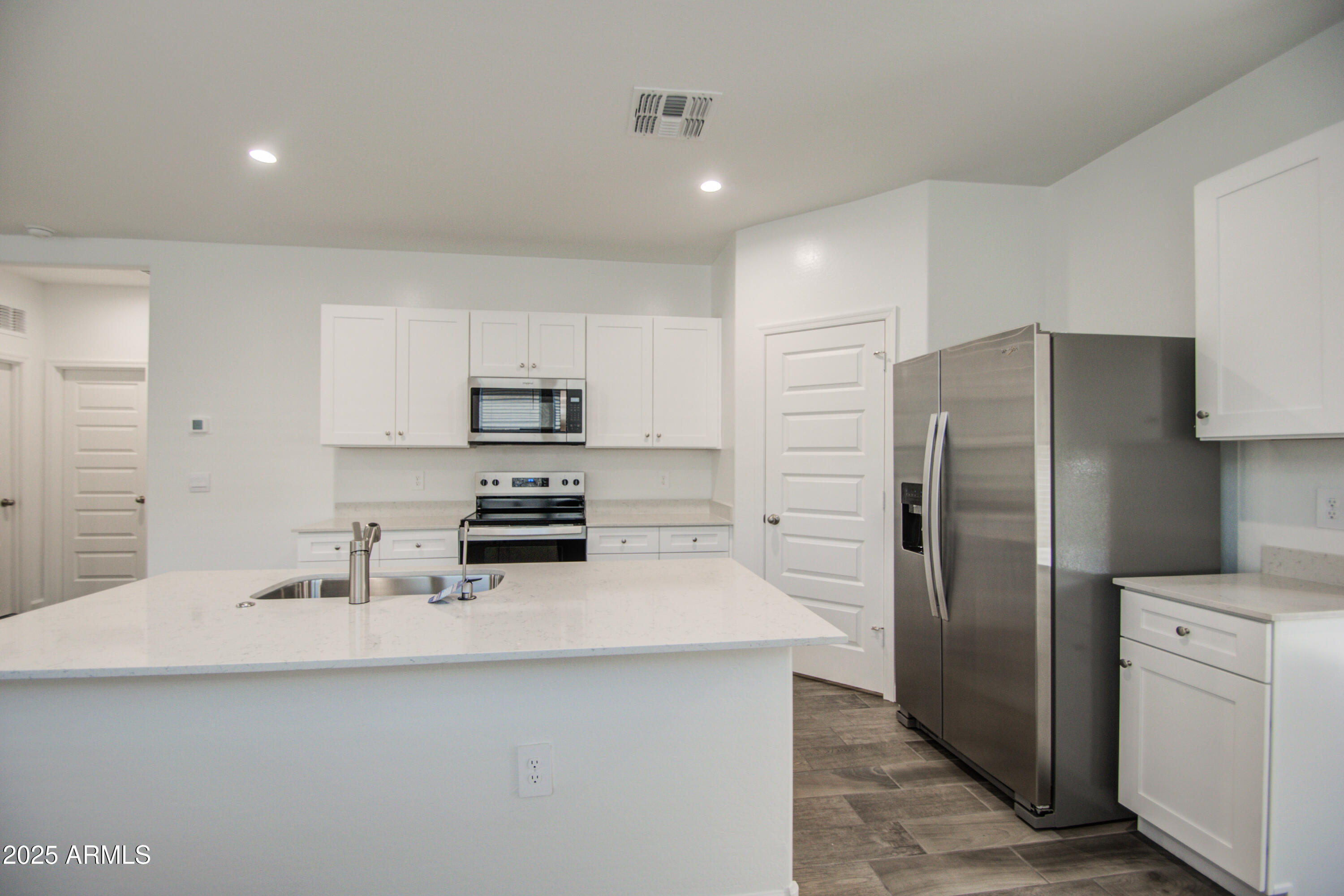 1749 West Stealth Avenue Apache Junction, AZ 85120 - Photo 7 of 48 a kitchen with a refrigerator sink and white cabinets