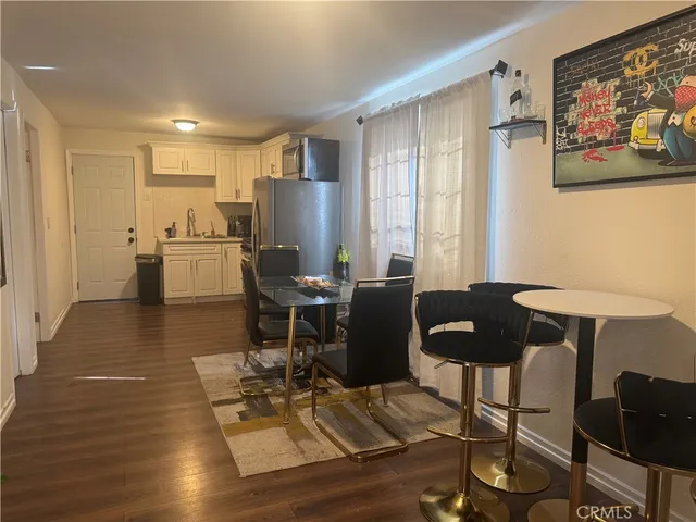 a view of a dining room with furniture a rug and wooden floor