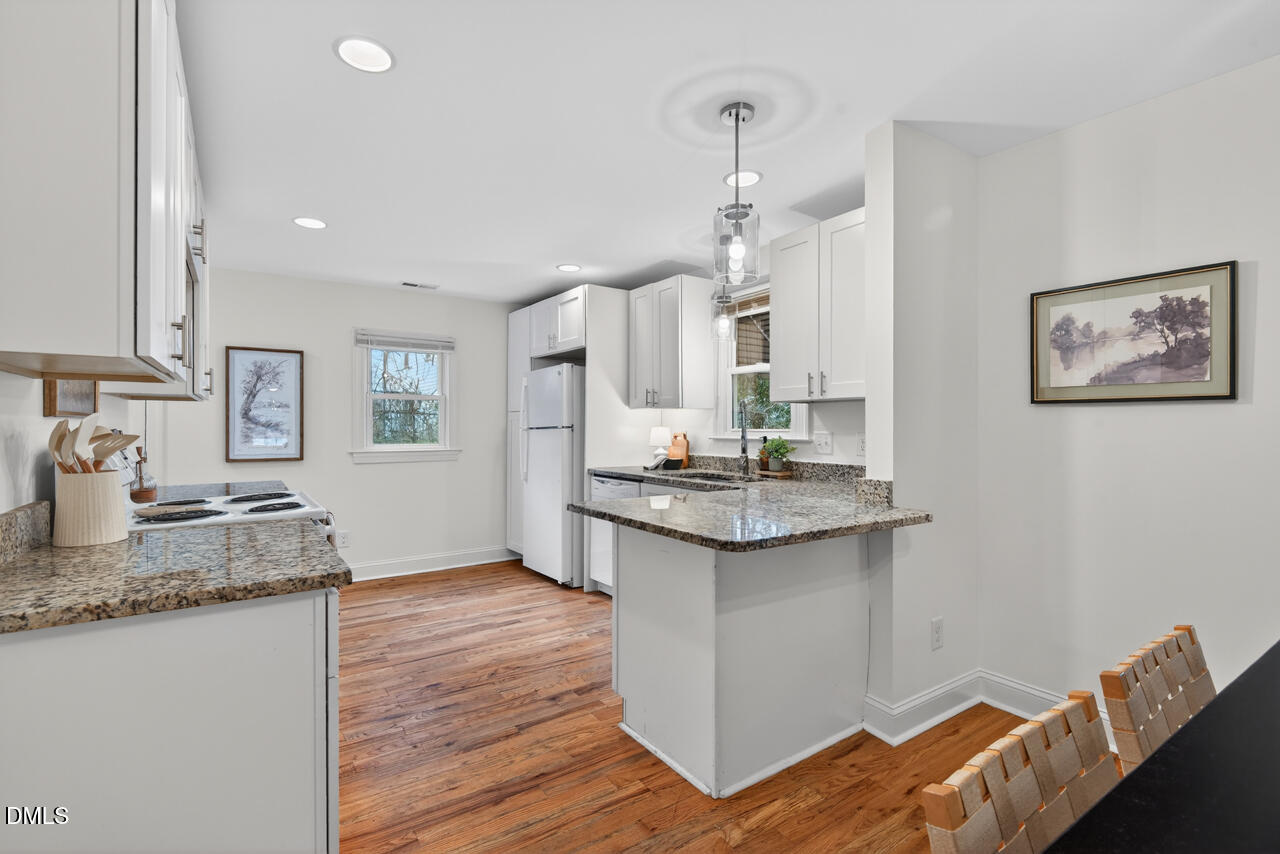 802 Cox Avenue Durham, NC 27701 - Photo 15 of 41 a kitchen with granite countertop a sink cabinets and wooden floor