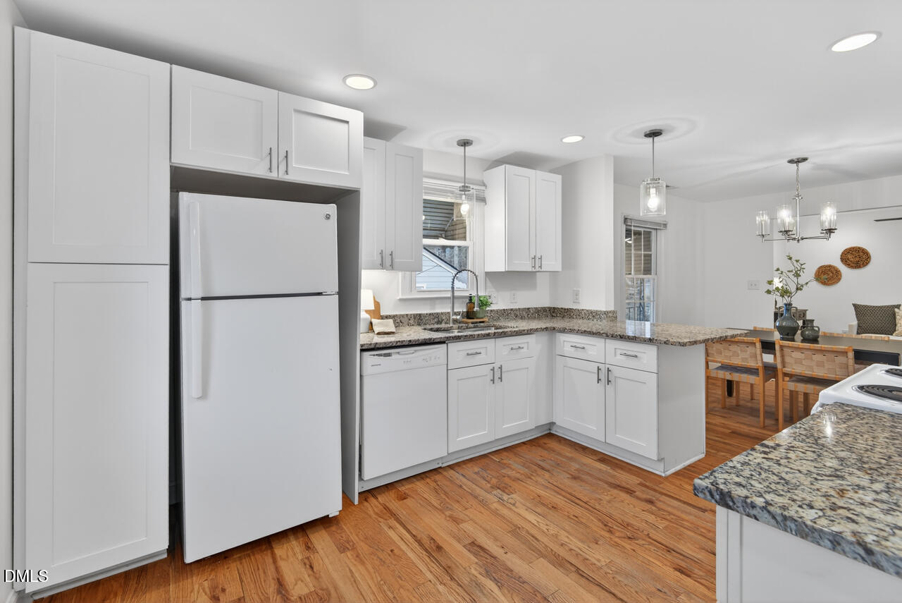 802 Cox Avenue Durham, NC 27701 - Photo 19 of 41 a kitchen with a refrigerator a sink and white cabinets