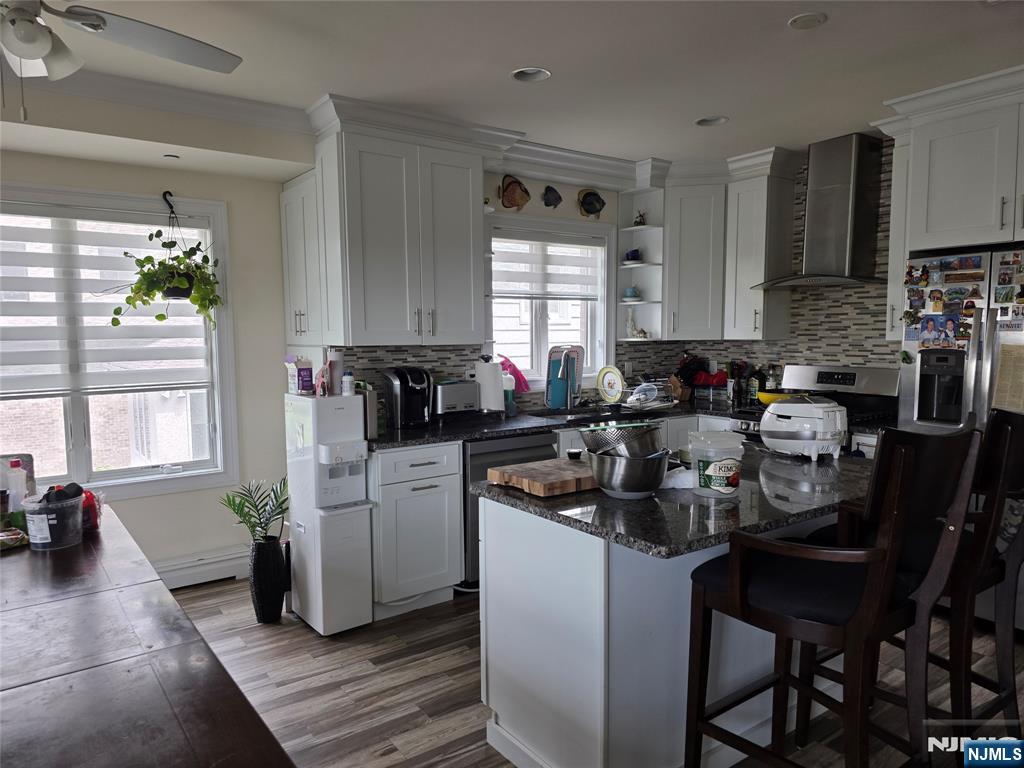 527 Roff Avenue, Unit B Palisades Park, NJ 07650 - Photo 3 of 11 a kitchen with a stove a sink a microwave a dining table and chairs