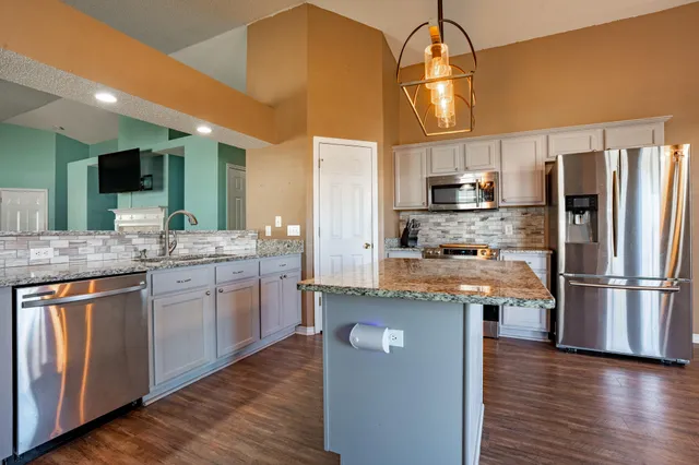 a kitchen with stainless steel appliances a refrigerator and a stove top oven