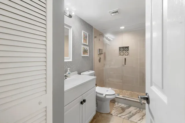 a bathroom with a sink a toilet and shower