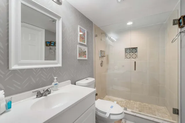 a bathroom with a sink a toilet and shower