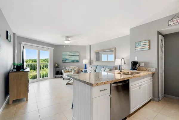 a kitchen with kitchen island granite countertop a sink stove and cabinets