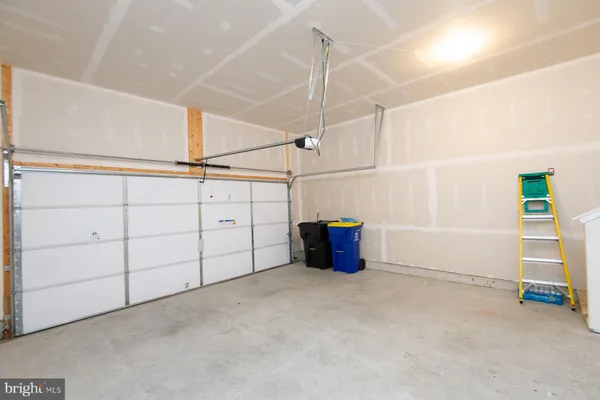 a kitchen with stainless steel appliances kitchen island granite countertop a refrigerator a stove a sink a dining table and chairs with wooden floor