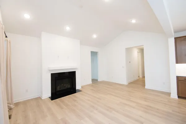 a kitchen with stainless steel appliances kitchen island granite countertop a sink a stove and a wooden floors