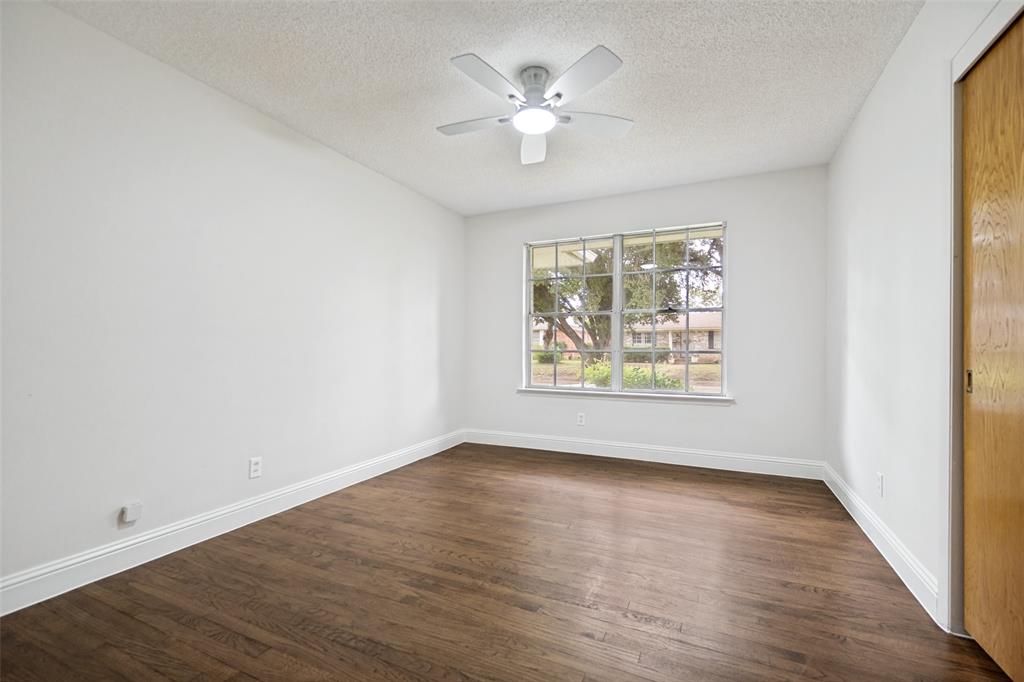 5319 Urban Crest Road Dallas, TX 75227 - Photo 16 of 21 Spacious room featuring wood-finish flooring, white baseboards, a multi-pane window, and a ceiling fan with integrated lighting