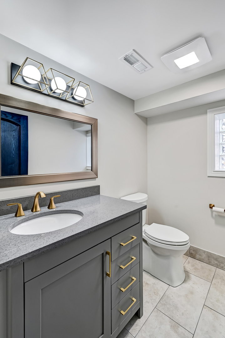 3220 Meyers Road Oak Brook, IL 60523 - Photo 25 of 43 a bathroom with a granite countertop toilet sink and mirror
