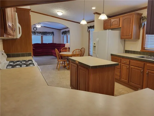 a kitchen with stainless steel appliances a sink a stove a refrigerator cabinets and wooden floor