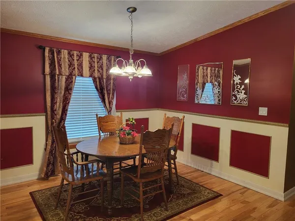 a view of a dining room with furniture wooden floor and chandelier