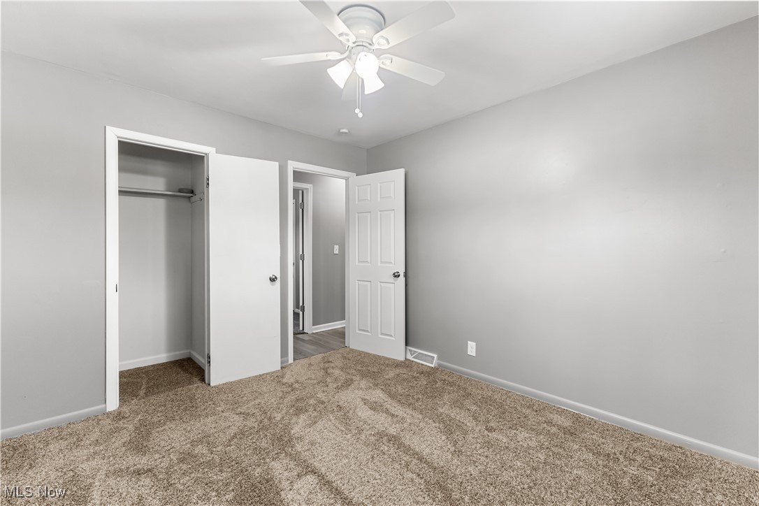 6161 Shaffer Road Northwest Warren, OH 44481 - Photo 16 of 20 Unfurnished bedroom with ceiling fan, a closet, and carpet