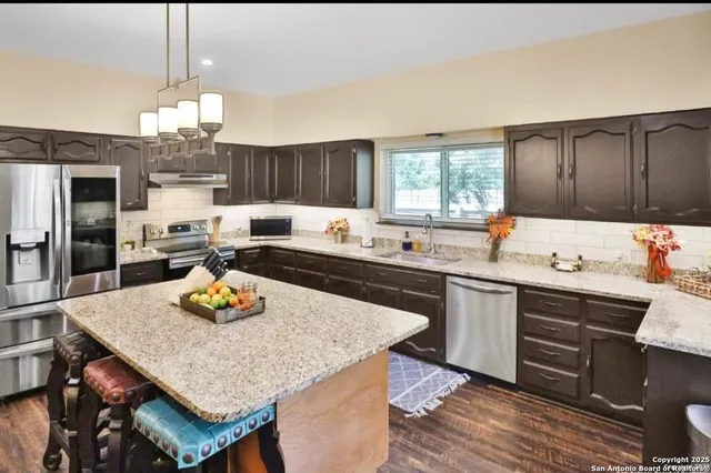 a kitchen with a sink a stove and chairs