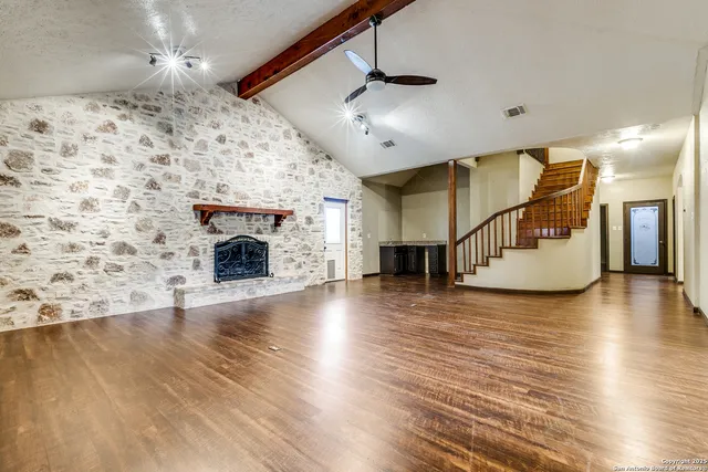 a view of a livingroom with wooden floor and a fireplace