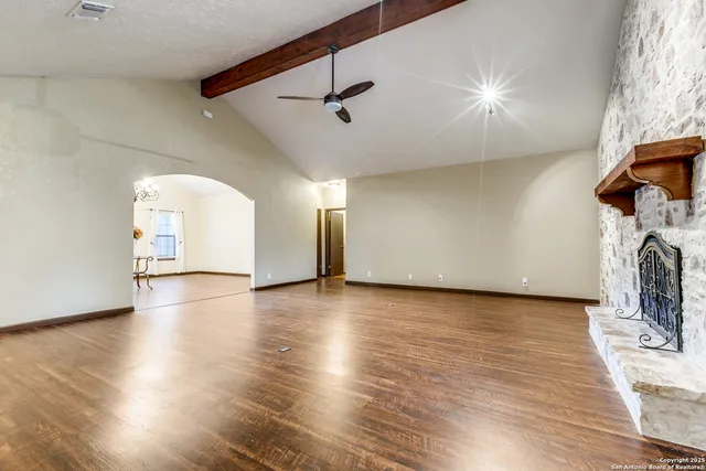 a view of a livingroom with wooden floor and a ceiling fan