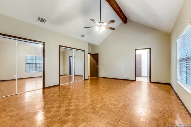 a view of an empty room with window and wooden floor