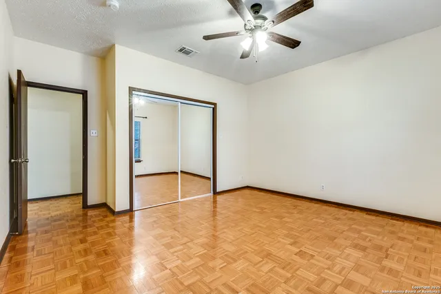 an empty room with fan and windows