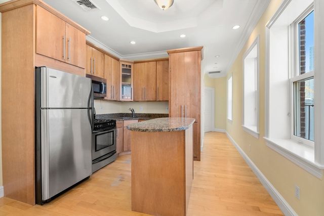 a kitchen with stainless steel appliances granite countertop a refrigerator a stove and a sink