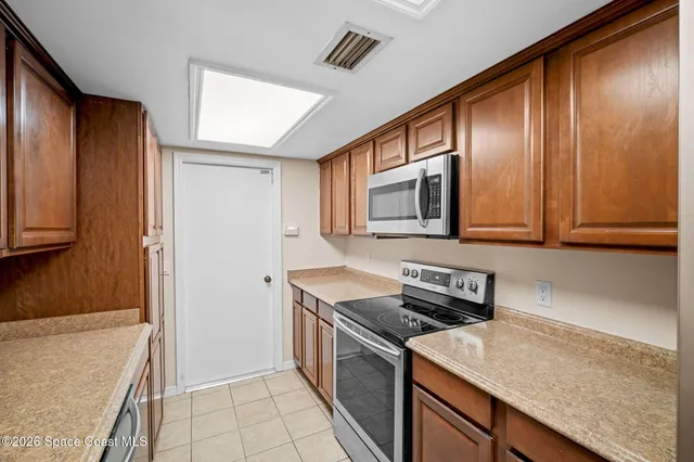 a kitchen with granite countertop stainless steel appliances a stove microwave and refrigerator