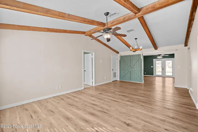 a view of empty room with wooden floor