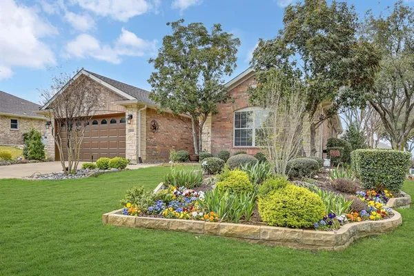 a front view of a house with a garden and plants