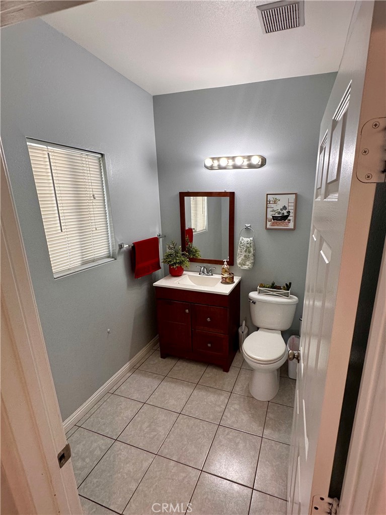 514 West Randall Avenue Rialto, CA 92376 - Photo 18 of 19 a bathroom with a toilet a sink a mirror and a rug