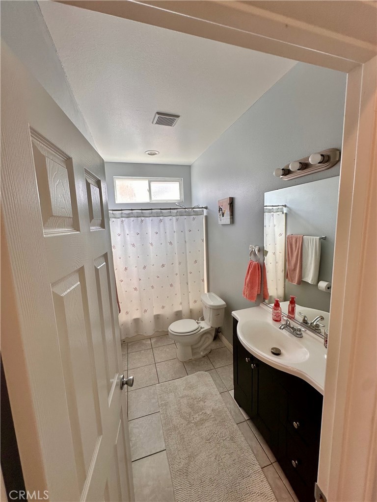 514 West Randall Avenue Rialto, CA 92376 - Photo 19 of 19 a bathroom with a sink a toilet and a mirror