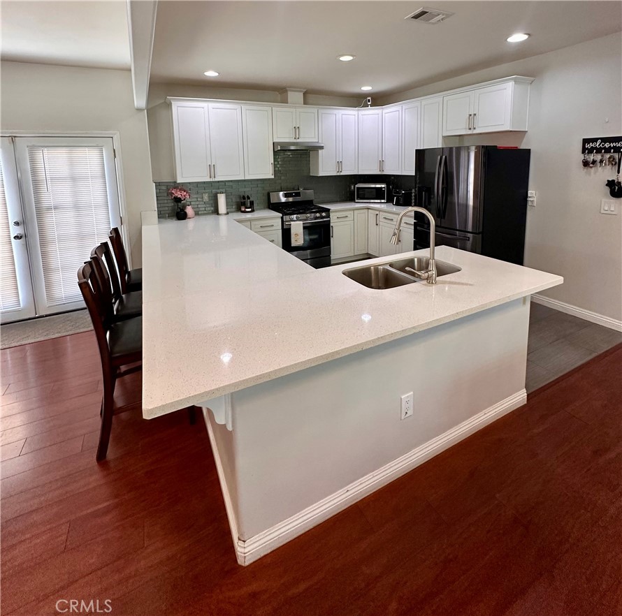 514 West Randall Avenue Rialto, CA 92376 - Photo 9 of 19 a kitchen with refrigerator and chairs