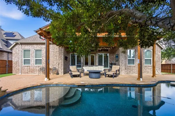 a view of a house with pool and chairs