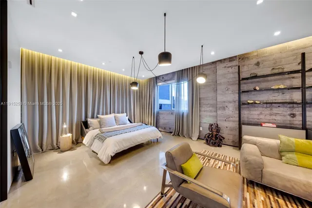 a spacious bedroom with a bed a couch and a chandelier