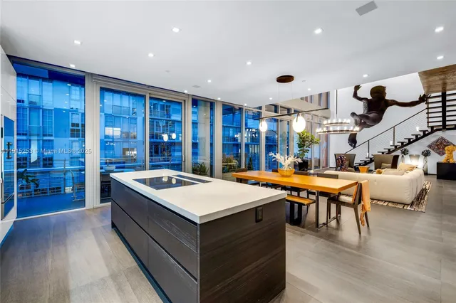 a large white kitchen with a large counter top and stainless steel appliances